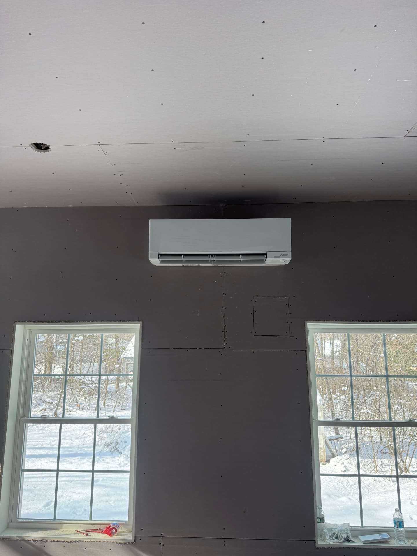 Mitsubishi indoor head centered between two windows in a new build
