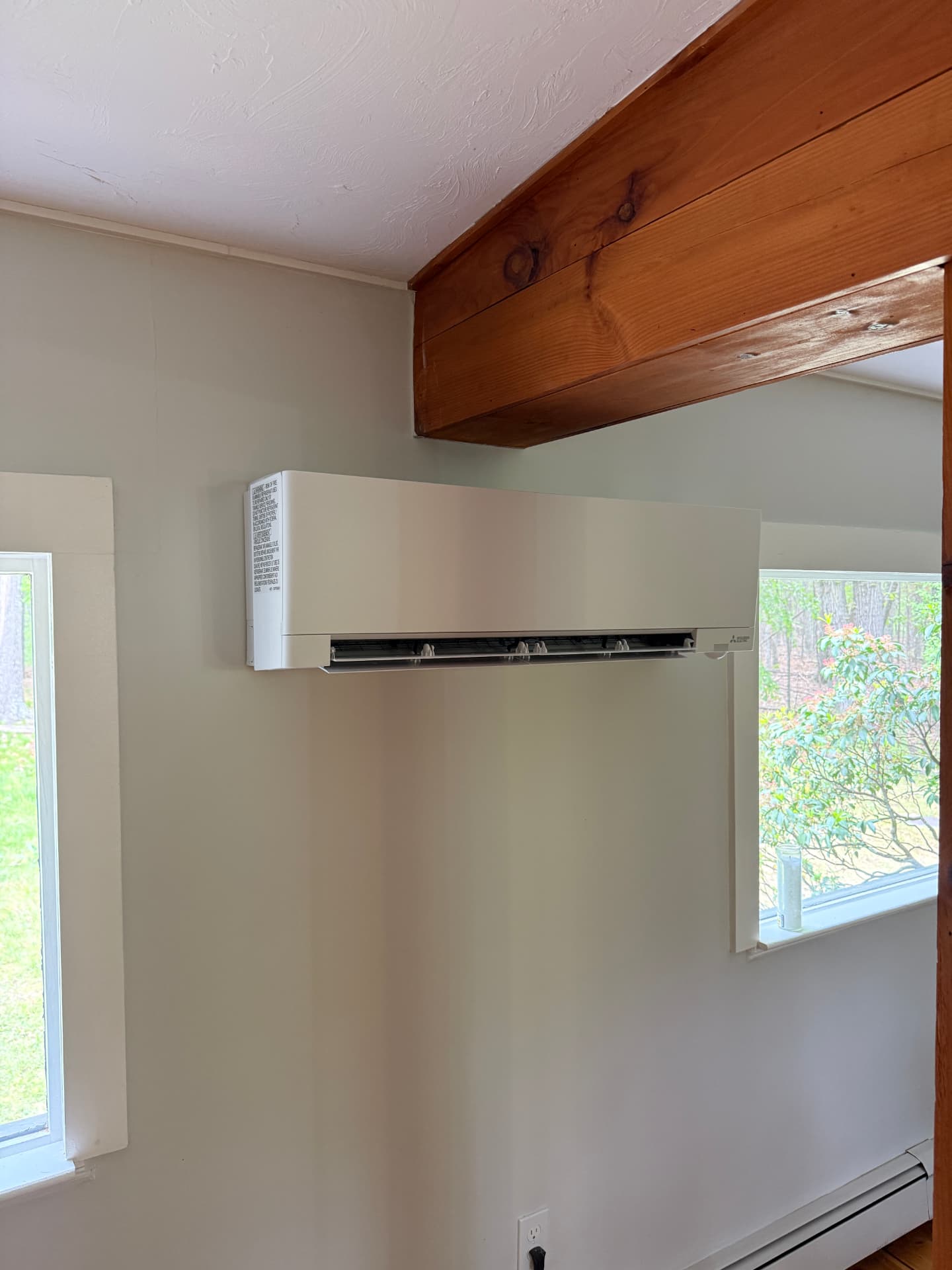 Mitsubishi indoor head installed beside a window under an exposed beam