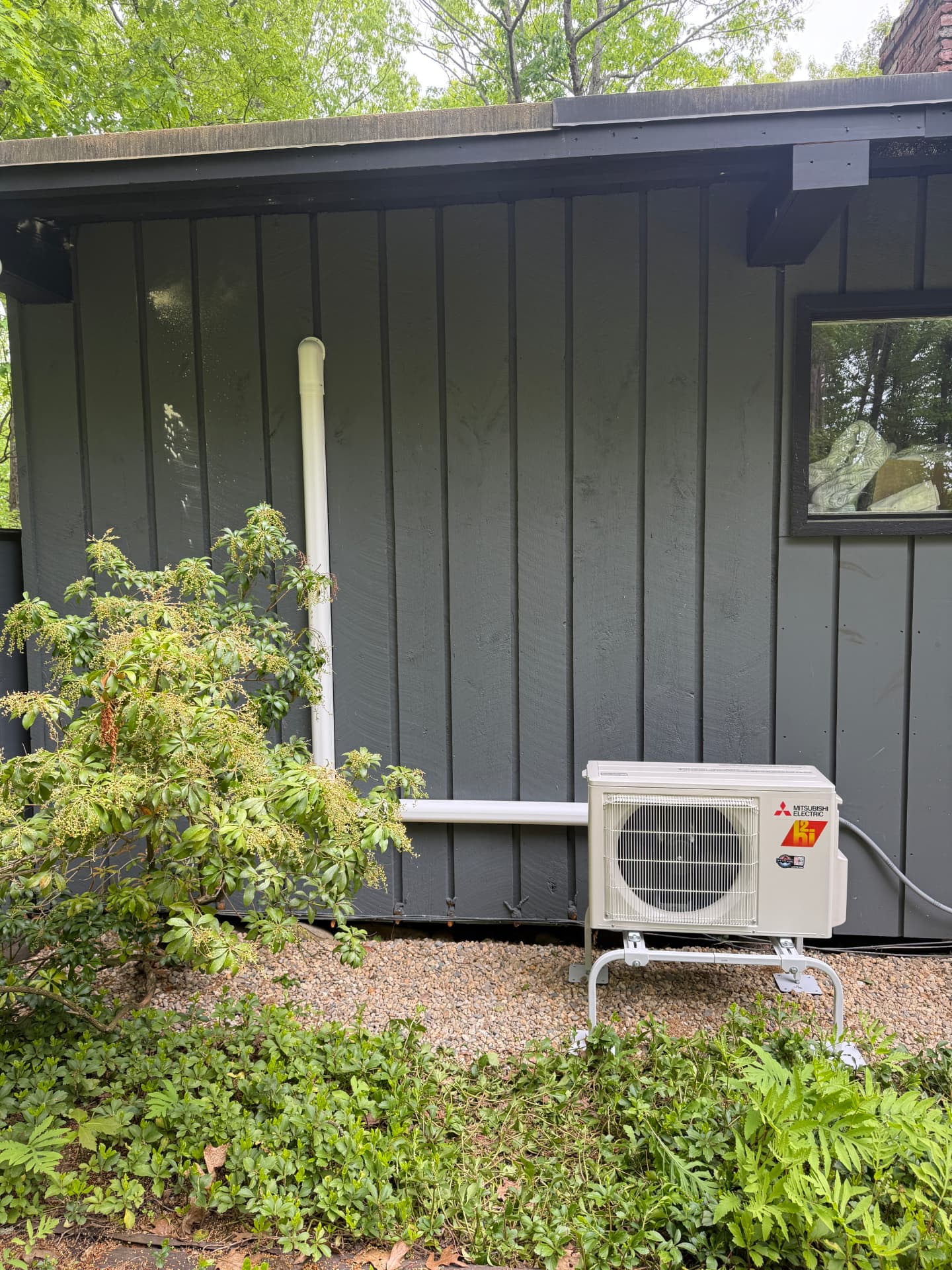 Mitsubishi condenser on a stand with clean white line-hide up the siding