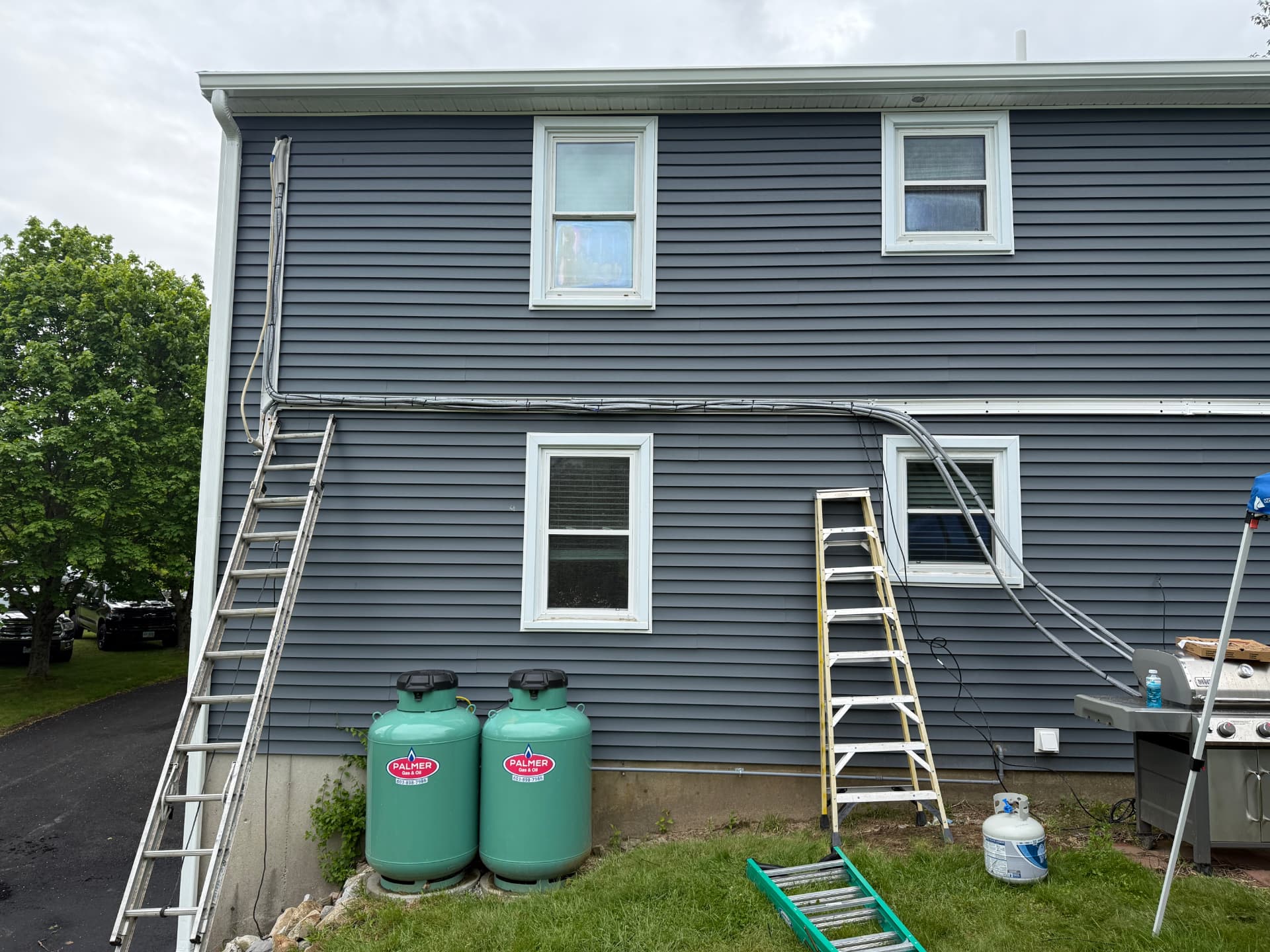 Line sets being run across a two-story exterior wall during installation
