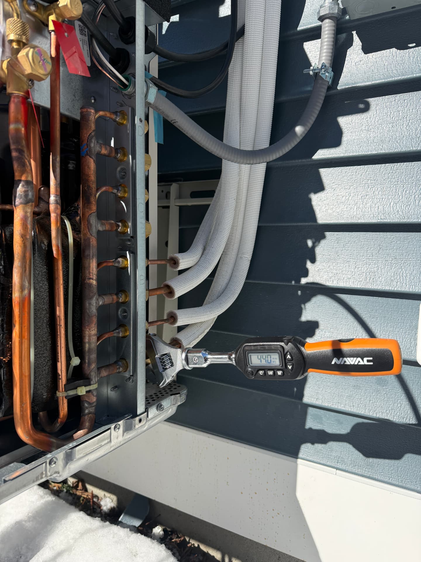 Torque wrench set to spec while connecting refrigerant lines at the condenser