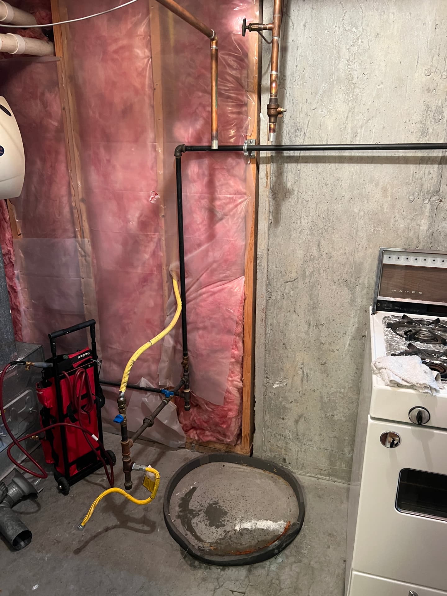 Hot water tank replacement in progress with gas and water lines prepped