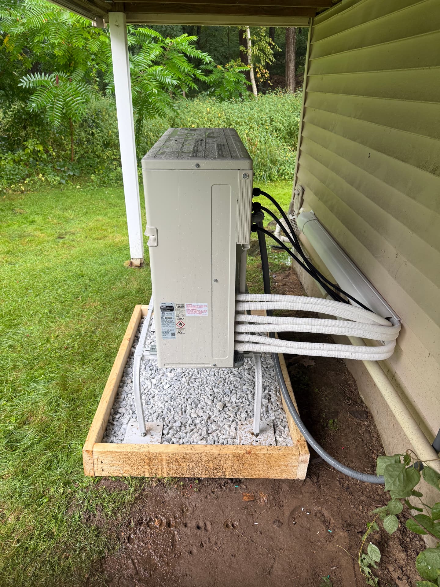 Side view of a mini split condenser with neatly run line sets and electrical